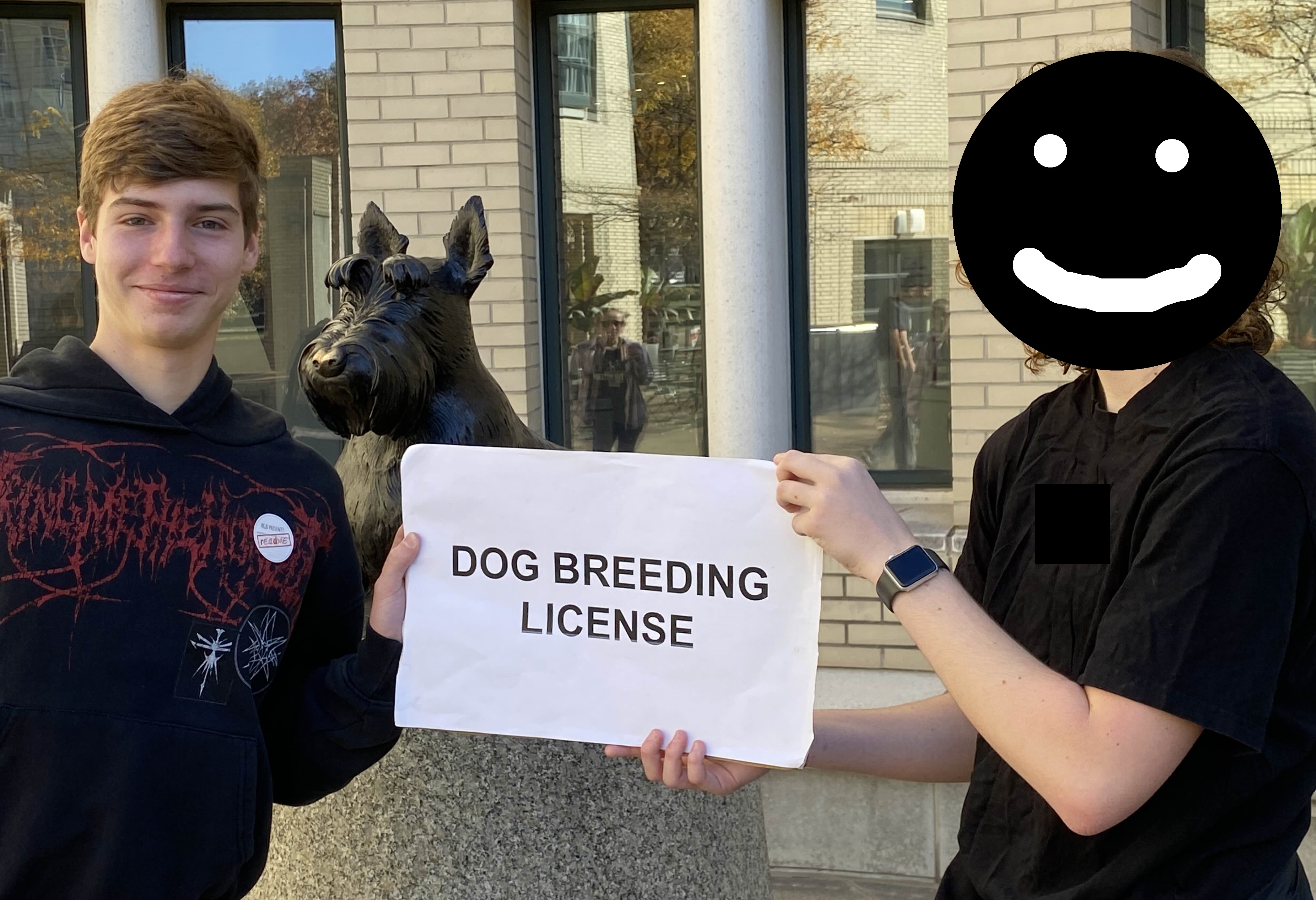 A photograph of a mysterious individual handing a large (11×17") piece of paper which says "DOG BREEDING LICENSE" in large bold font to an "unidentified, dashing Readme staffer" in front of the bronze Scotty dog sculpture outside the Cohon University Center. The unidentified staffer is indeed quite dashing. In the photo they're wearing a Bring Me The Horizon hoodie with a readme sticker.